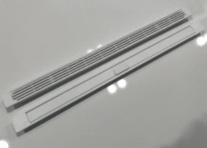 A pair of white trickle vents on a white surface.